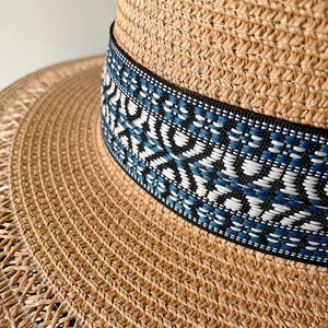 Dettaglio ravvicinato del cappello di paglia che mostra la trama intrecciata e il nastro