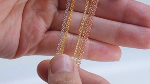 Macro shot of thin sterling silver chains in silver, gold, and rose gold finishes