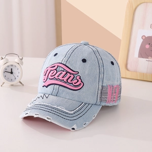 Détail d'une casquette de baseball en jean bleu clair avec broderie 3D rose et visière usée