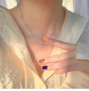Close-up of sparkling twist titanium steel choker necklace on woman's neck