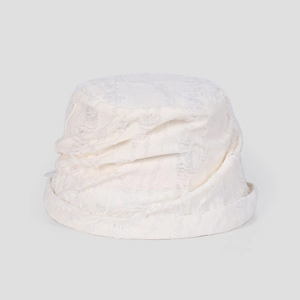 Detailed texture of off-white frayed bucket hat with vintage distressed tassel design