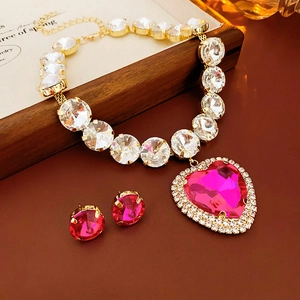 Detail of pink heart crystal necklace and matching stud earrings set in gold finish