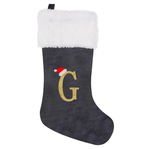 Close-up of grey velvet Christmas stocking with golden glitter G and faux fur trim