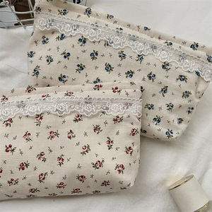 Close-up of floral canvas storage bags featuring vintage lace trim and cotton texture