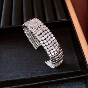 Macro detail of silver multi-row round disc sequins on a flexible layered bracelet