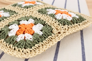 Gros plan détaillé montrant le motif de fleurs au crochet et la texture tissée du sac à main