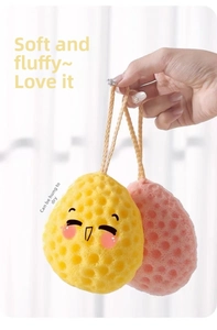 Close-up of soft honeycomb bath sponges with cute cartoon faces and hanging ropes