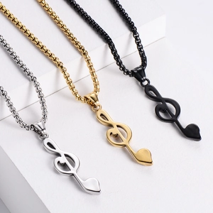 Minimalist musical note pendants in silver, gold, and black on white stone steps