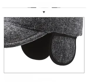 Macro detail of winter peaked cap with earflaps and grey herringbone tweed fabric