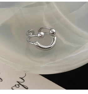 Macro detail of silver double-layered open ring with metal beads on wavy display