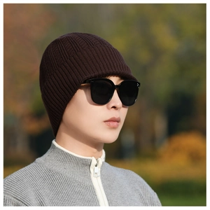 Detailed close-up of dark brown knit beanie with short brim and thick warm texture