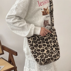 Detailed close-up of leopard print faux fur shoulder bag texture with wide strap