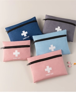 Flat lay of four colorful first aid kit pouches in blue, gray, and pink oxford fabric