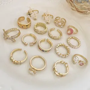 Collezione di anelli dorati di lusso con zirconi, fiori eleganti e dettagli in perla