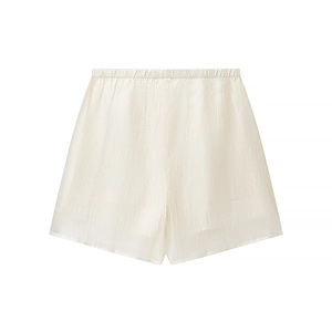 Detail of high-waist cream shorts featuring elastic waistband and textured fabric