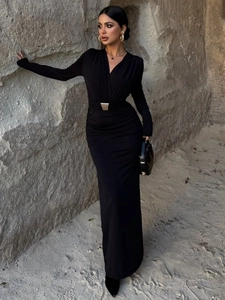 Detail of slim-fit black maxi dress with V-neckline and silver geometric waist belt