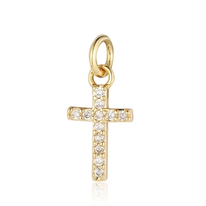 Detail of a golden cross pendant with shimmering cubic zirconia on white background