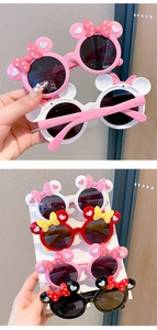 Detail of pink and red cartoon sunglasses with bow and mouse ears for little girls