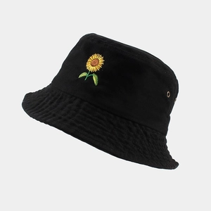 Détail de la broderie tournesol et des œillets métalliques sur un bob en coton noir