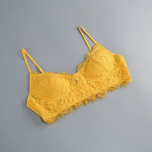 Dettaglio di un top in pizzo giallo con ricami floreali e bordi in pizzo a ciglia
