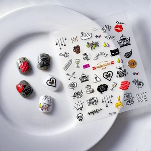 5D Christmas nail art stickers with heart and devil wing designs on white ceramic plate