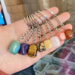 Set of seven irregular natural crystal agate stone keychains held in hand for bag decor