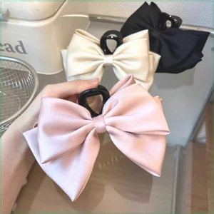 Large satin bow hair claw clips in pink, cream white, and black for elegant updos