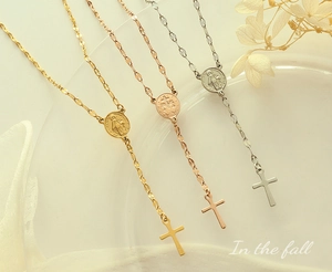 Close-up of gold and silver Y-shaped necklaces with religious medals and cross pendants