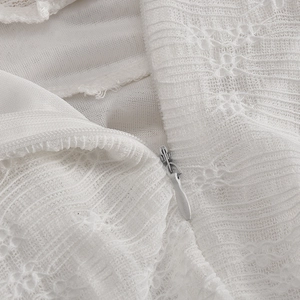 Détail macro de la dentelle blanche et fermeture éclair invisible sur la robe