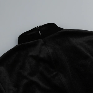 Gros plan sur la fermeture éclair invisible d'une robe en velours noir à col haut