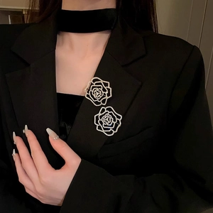 Close-up of two sparkling zircon flower brooches styled on a black suit jacket lapel