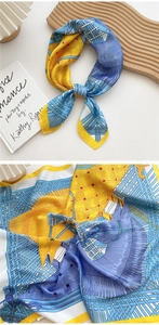 Detailed close-up showing the 3D basketweave pattern and yellow rolled edge of the silk scarf