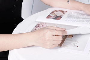 Detail of rose gold ring with micro-pave setting worn by model on a minimalist background