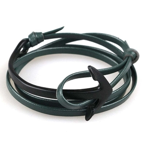 Detail of green leather multi-layer wrap bracelet with black anchor clasp on white background