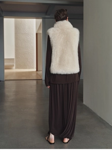 Back view of a plush faux fox fur cashmere vest in cream white on a model