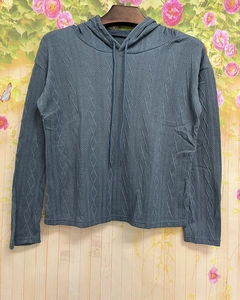 Dettaglio del tessuto a trecce blu-grigio della felpa con cappuccio e coulisse regolabile