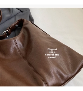 Detail of soft brown faux leather hobo bag showing retro texture and silver metal buckle