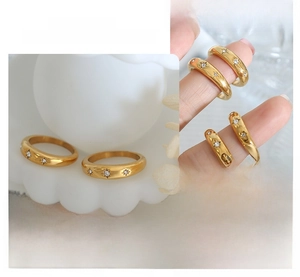 Detail of 18K gold plated stainless steel ring with sunburst carving and zircon inlay