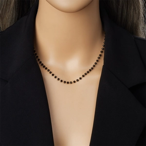 Minimalist black beaded necklace with gold chain shown on mannequin neck display