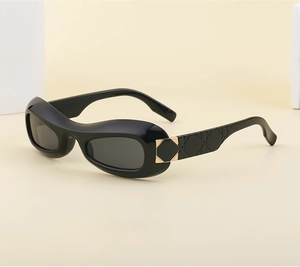 Detail view of oval sunglasses featuring black frames and gold-tone diamond quilted temples