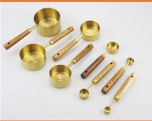 Detail of 8pcs brass measuring cups and spoons with acacia wood handles and laser engravings