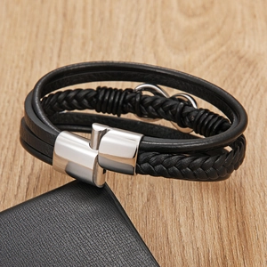 Macro detail of braided black leather bracelet with silver infinity charm and magnetic clasp