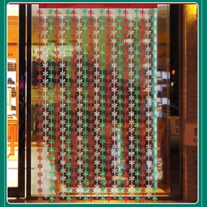 Close-up of red, green and silver snowflake tinsel curtain for Christmas party decor