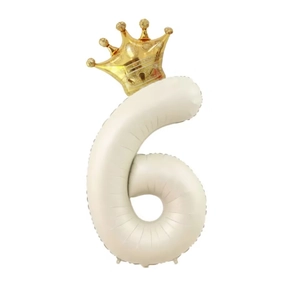 Detail of a cream number 6 balloon with a golden crown for kid's birthday party decor