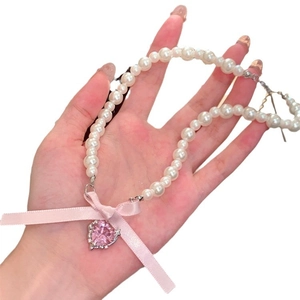 Pink heart gemstone pendant with pearl necklace and ribbon bow, elegant romantic style