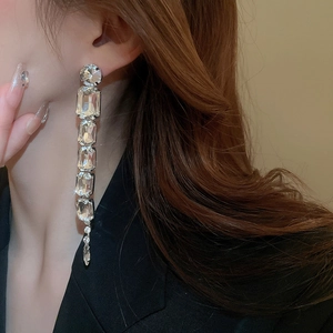 Close-up of elegant silver tassel earrings with crystals on a model for a luxury look