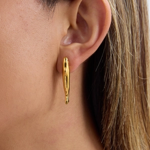 Elegant gold teardrop earrings for women worn by model in a minimalist luxury style