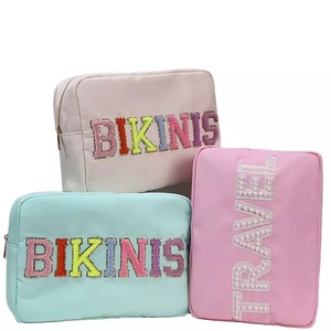 Three nylon makeup bags in pink and blue with BIKINIS and TRAVEL letter patches