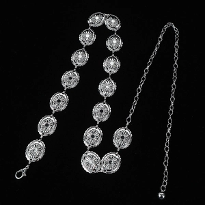 Silver metal concho waist chain belt with vintage engraved oval disks on black background