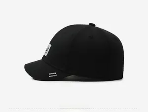 Detail of black cotton baseball cap showing side fabric label and white zigzag stitching